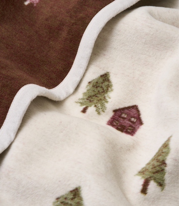 Cream blanket with white trim featuring embroidered green trees and burgundy cabin design.4