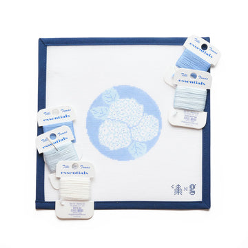 Needlepoint canvas with blue hydrangea flowers and white petals on light background, with blue frame and color-coded embroide3