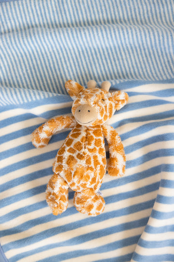 Blue and white striped mini blanket with orange and white giraffe plush toy.7